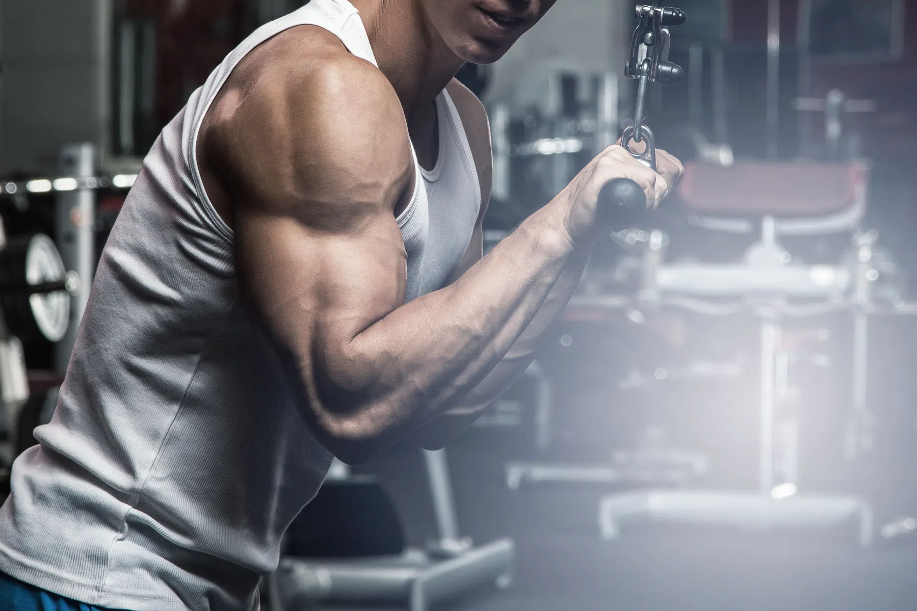 Man doet tricep pushdown in sportschool